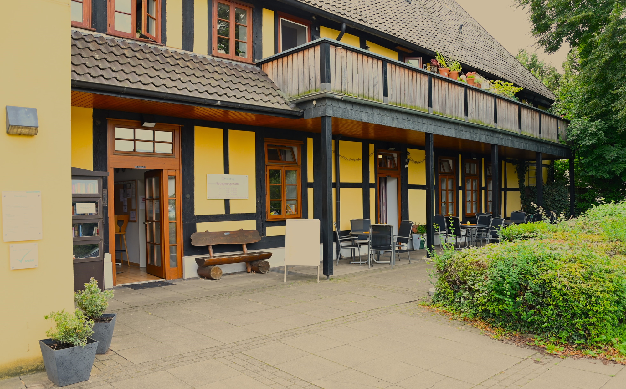 Fachwerkgebäude mit Sitzgelegenheiten vor der Begegnungsstätte